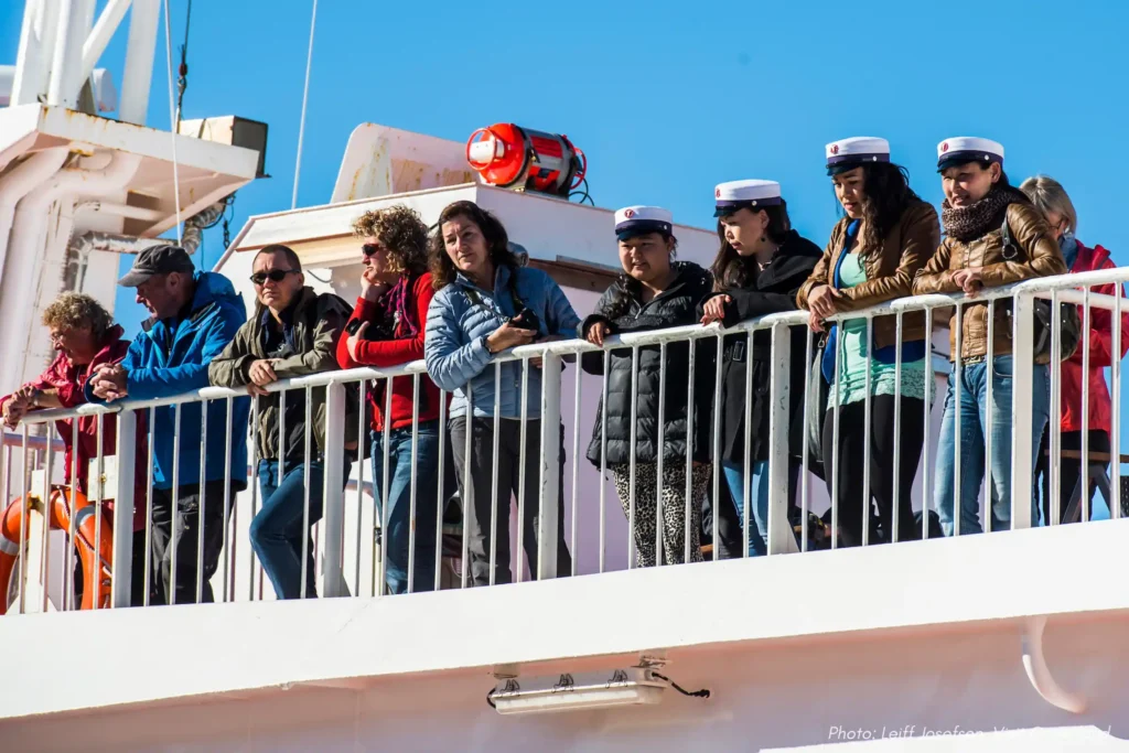 Copy of Local student graduates and tourist on the upper deck of coastal ferry Sarfaq Ittuk in Greenland