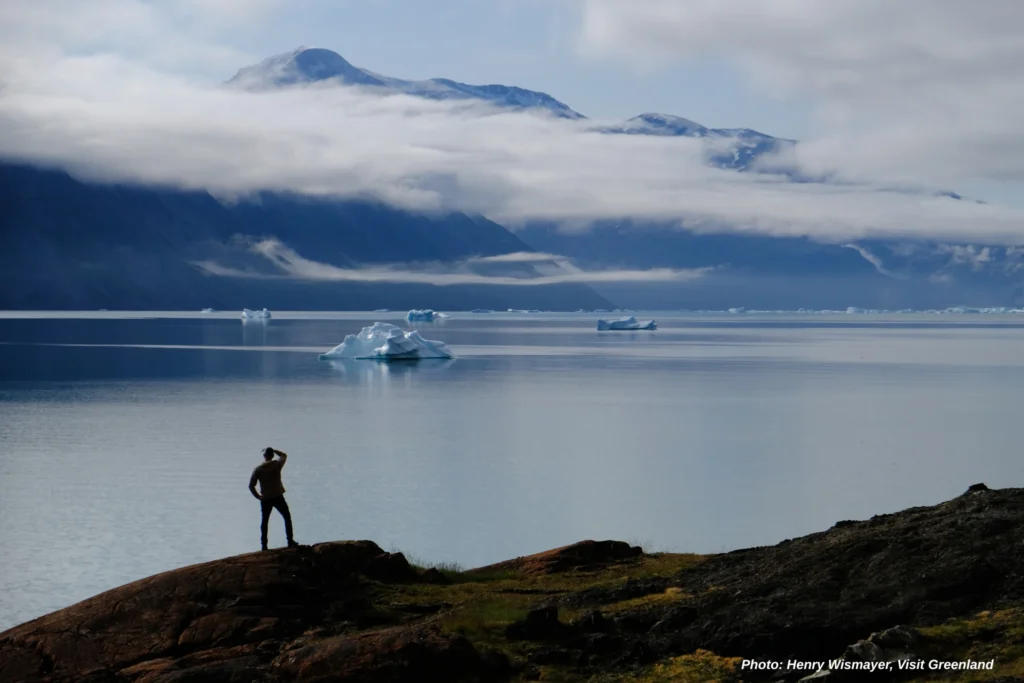 Guide Erik Kielsen looks out over the Tunulliarfik Fjord from a coastal ridge in Qassiarsuk. Photo by Henry Wismayer - Visit Greenland