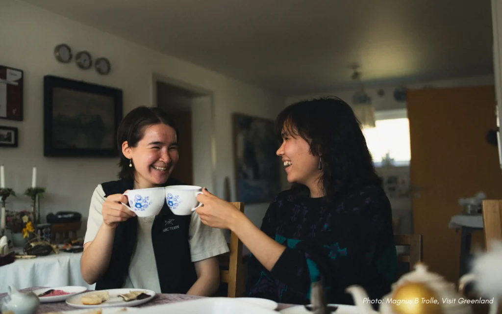 Smiling with coffee and tea at kaffemik in qaqortoq