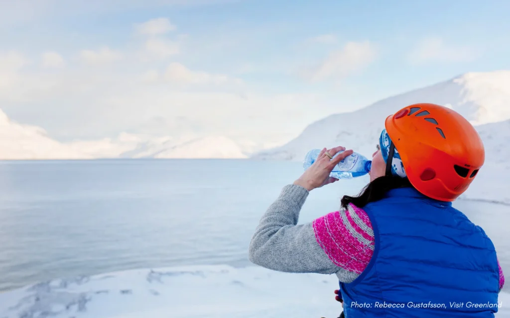 Tourist taking a water break on winter hike in Nuuk in Greenland